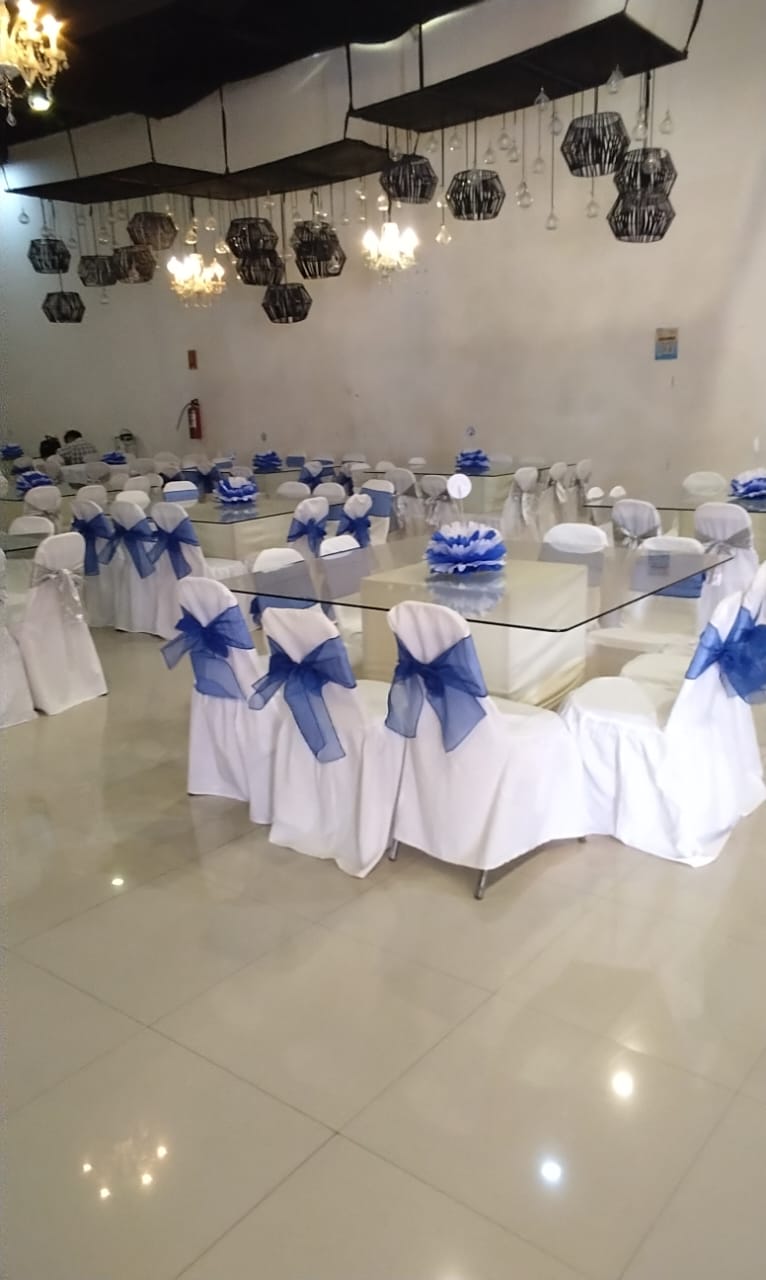 Montaje de XV Años con Moños Azul Rey de Satín, Mesas Cuadradas y Candiles Colgantes