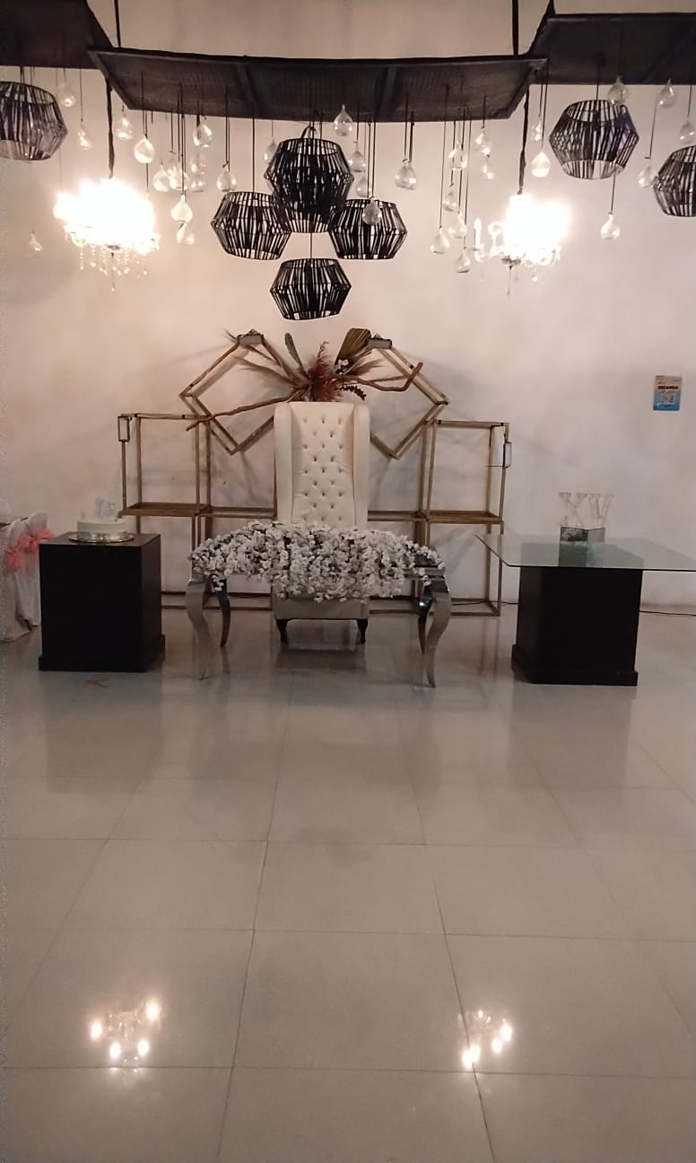 Escenario de XV Años con Marco Geométrico Dorado, Arreglos Florales de Rosas y Follaje