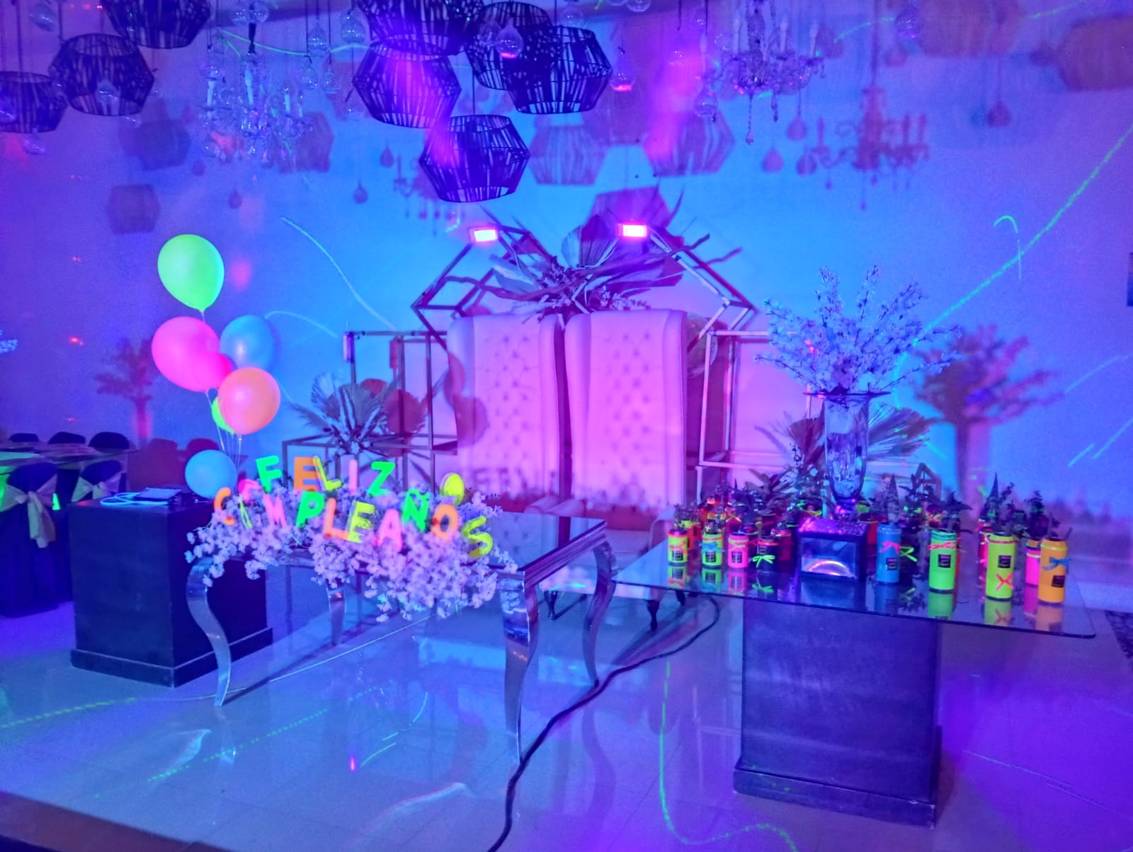 Escenario de Fiesta Neón con Sillones Trono Capitonados, Flores y Letrero Feliz Cumpleaños Luminoso