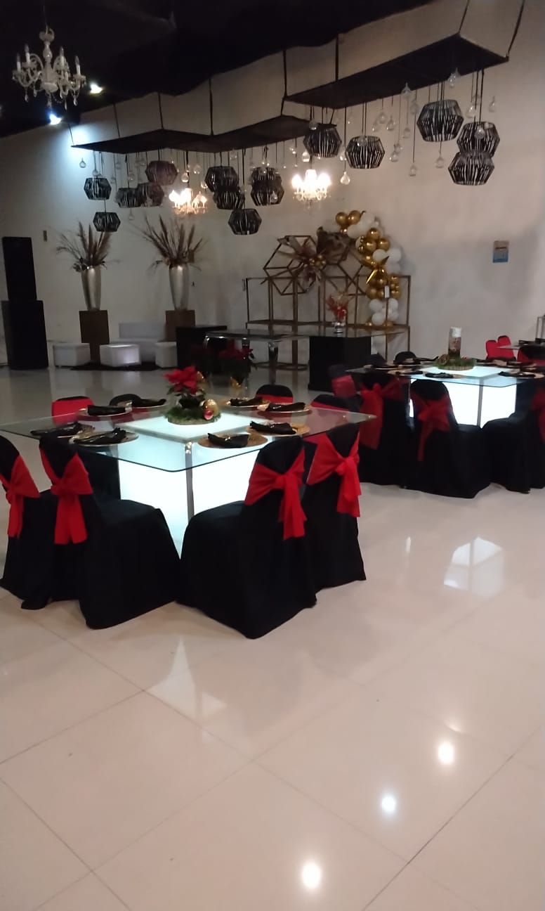 Montaje Especial de Posada Navideña con Nochebuenas Naturales, Esferas Doradas, Moños Rojos y Mesas Cubo de Luz en Salón Bella Terra